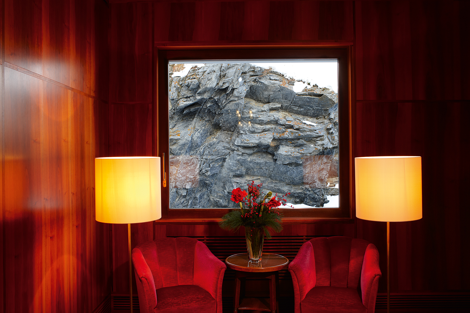 red interior room with a view of rocks from window