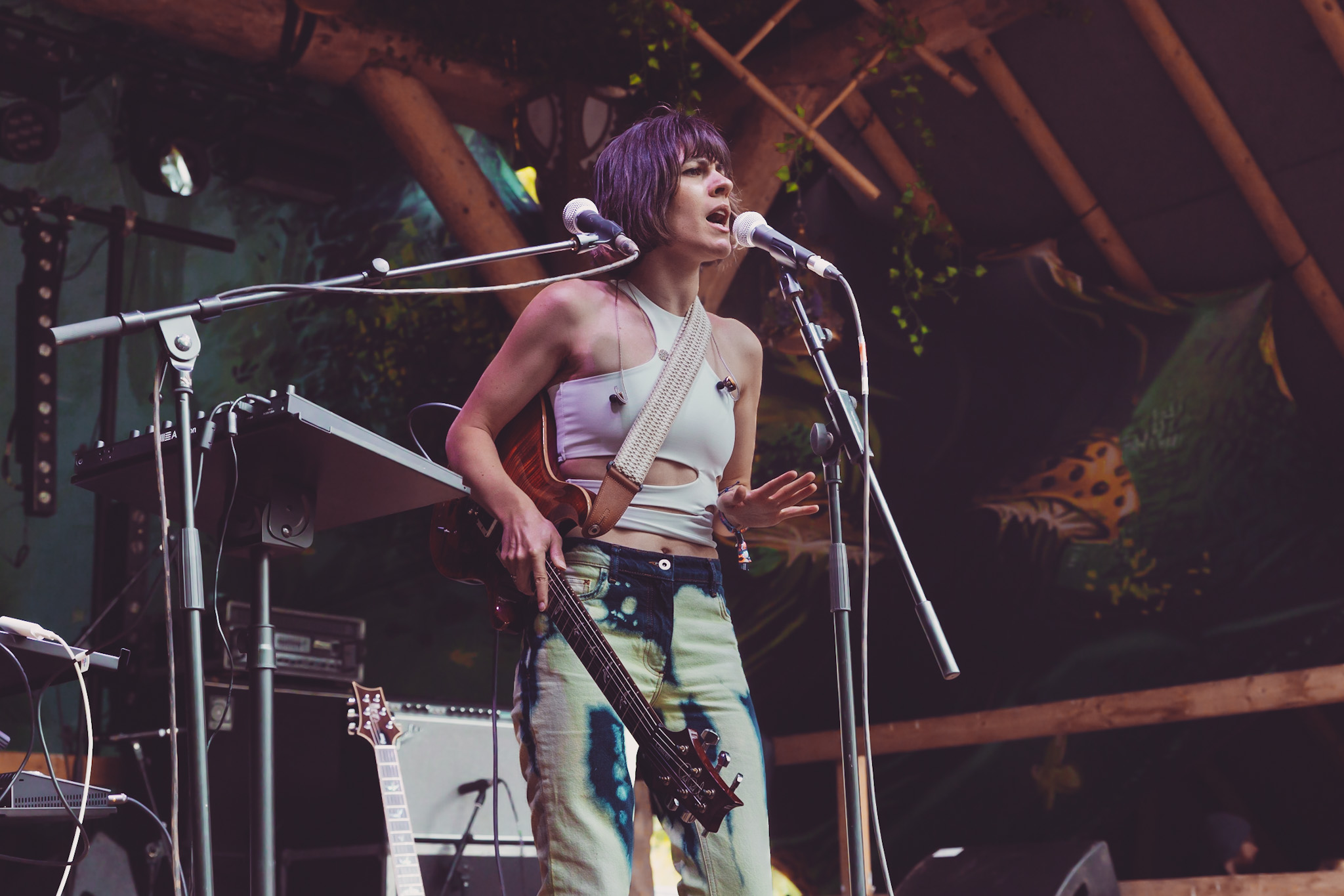 a woman with a guitar singing into a microphone