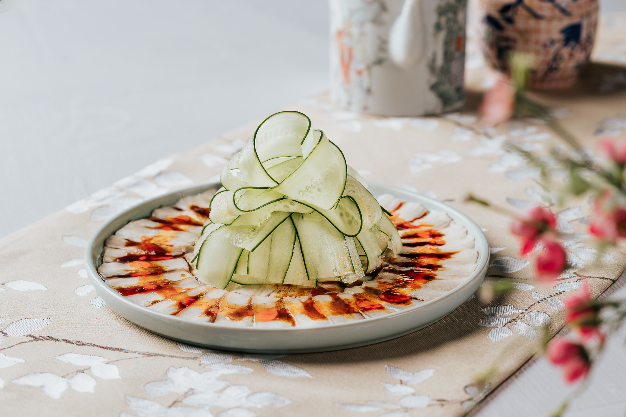 a plate of food with green vegetables and red chilli